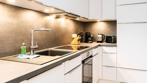Une cuisine moderne équipée d’un évier en acier inoxydable, d’une machine à café et d’un grille-pain.