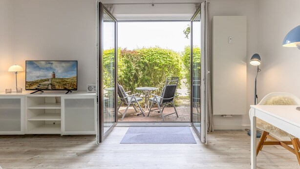 A modern room with a sliding glass door leading to an outdoor patio area.