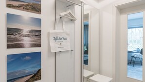 Une salle de bain d’hôtel équipée d’une douche, d’un miroir et d’un porte-serviettes.