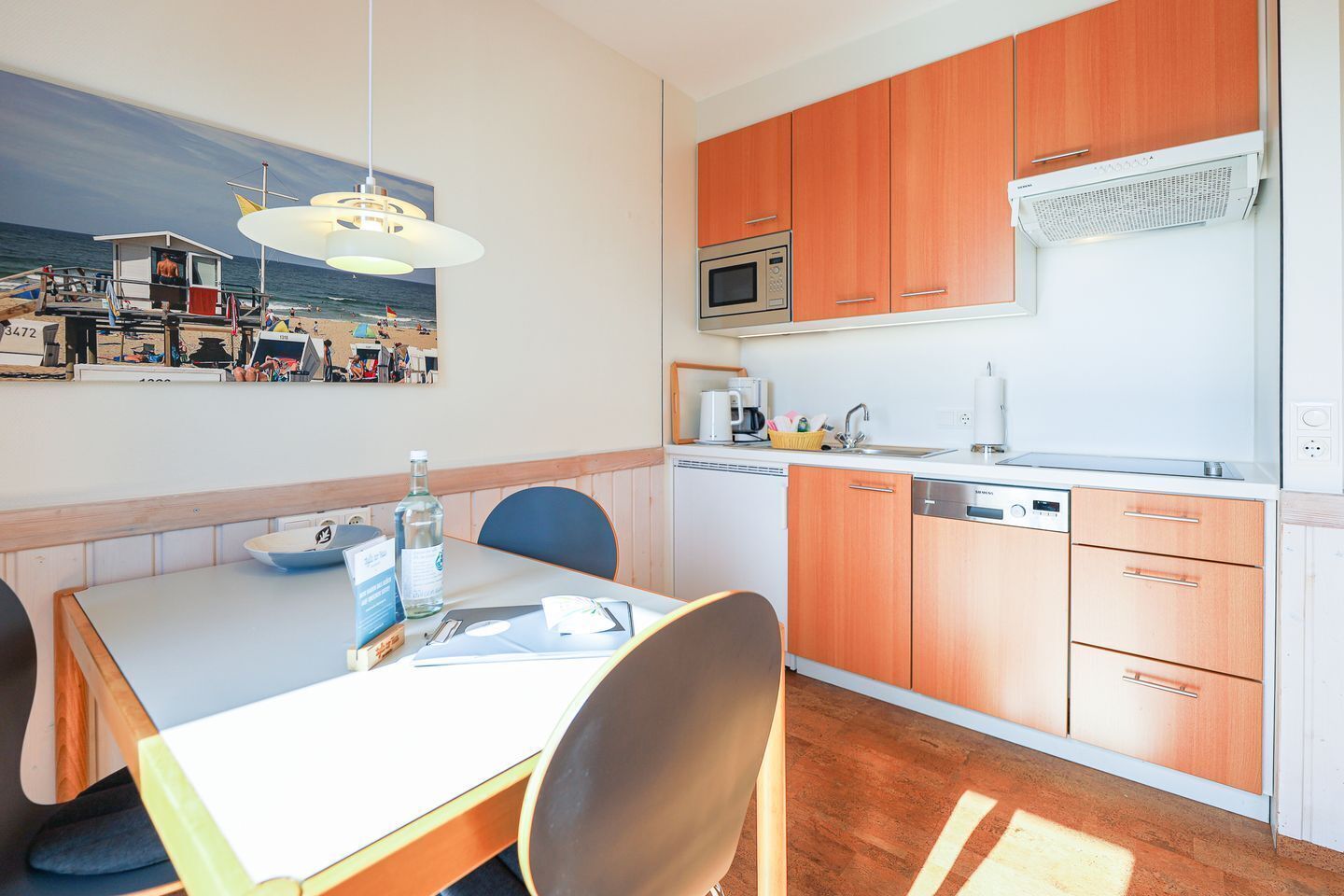 A compact kitchen with wooden cabinets, a microwave, and a dishwasher.