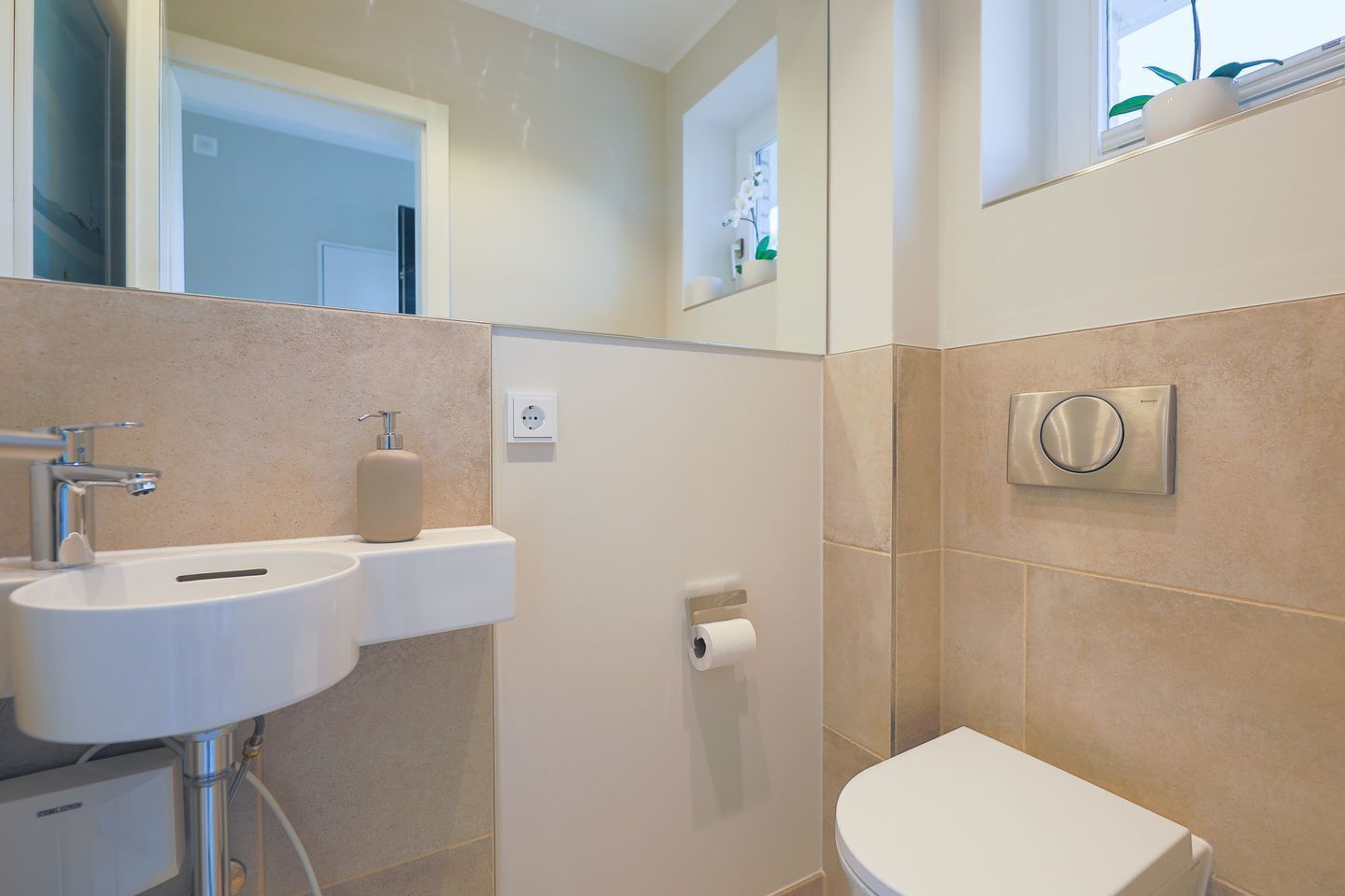 Une salle de bain équipée d’un lavabo, d’un miroir, de toilettes et d’une douche.