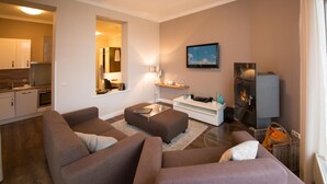 A modern living room with a sofa set, a coffee table, a TV, and a fireplace. - Rainer Maria Rilke apartment in the author's house on Usedom! - Author's House Usedom (Heringsdorf)