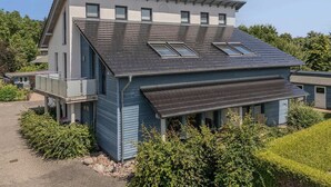 A modern two-story house with a sloped roof, multiple windows, and a covered porch area. - Apartment in Zinnowitz with balcony and WLAN - close to the beach on Usedom - House (Zinnowitz)