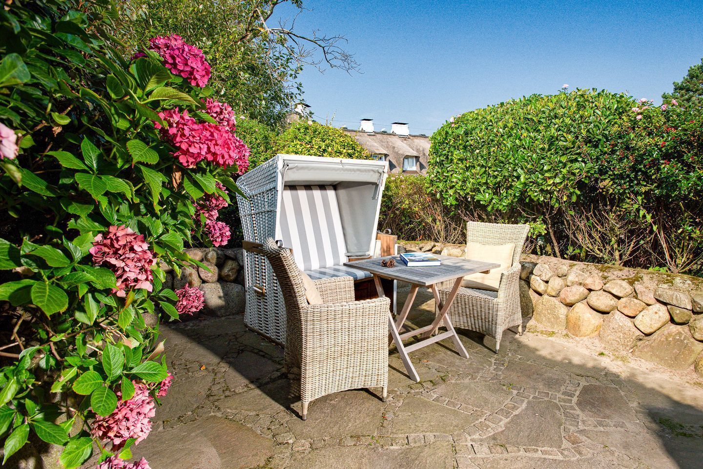 A patio with wicker furniture, a table, and a covered seating area.