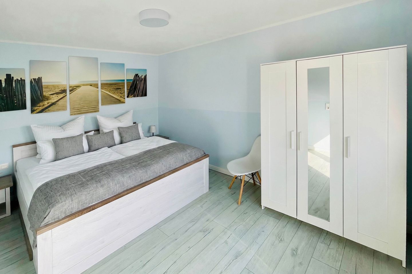 Een slaapkamer met een groot bed, een kledingkast en wanddecoratie.