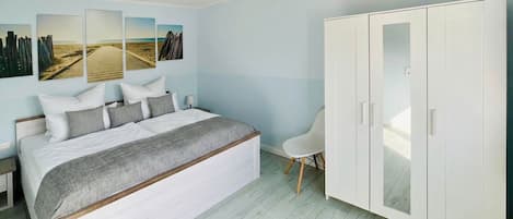 Een slaapkamer met een groot bed, een kledingkast en wanddecoratie.