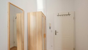 A room with a wooden door, a white wall, and a mirror reflecting part of the room. - Charming vacation apartment in Heringsdorf, just 400 m from the beach - Villa (Heringsdorf)