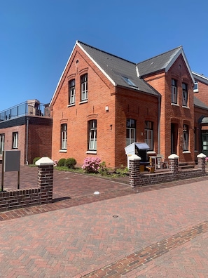 A red brick building with a pitched roof and multiple windows.