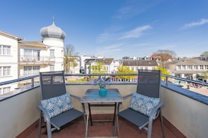 A balcony with two chairs, a table, and a vase of flowers. - Apartment Karlskrona in Ahlbeck with balcony, close to the beach - Haus Skanska (Heringsdorf)