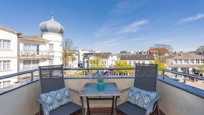 A balcony with two chairs, a table, and a vase of flowers. - Apartment Karlskrona in Ahlbeck with balcony, close to the beach - Haus Skanska (Heringsdorf)