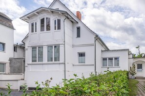 A two-story residential building with a gabled roof, multiple windows, and a brick chimney. - Apartment Karlskrona in Ahlbeck with balcony, close to the beach - Haus Skanska (Heringsdorf)