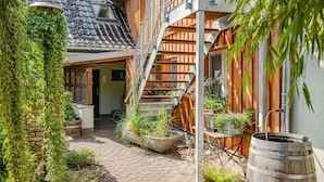 Ein traditionelles Holzhaus mit geneigtem Dach, einer Holztreppe und einem Pflasterweg.