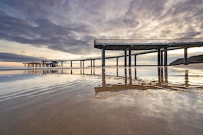 Un muelle se adentra en aguas tranquilas bajo un cielo nublado.
