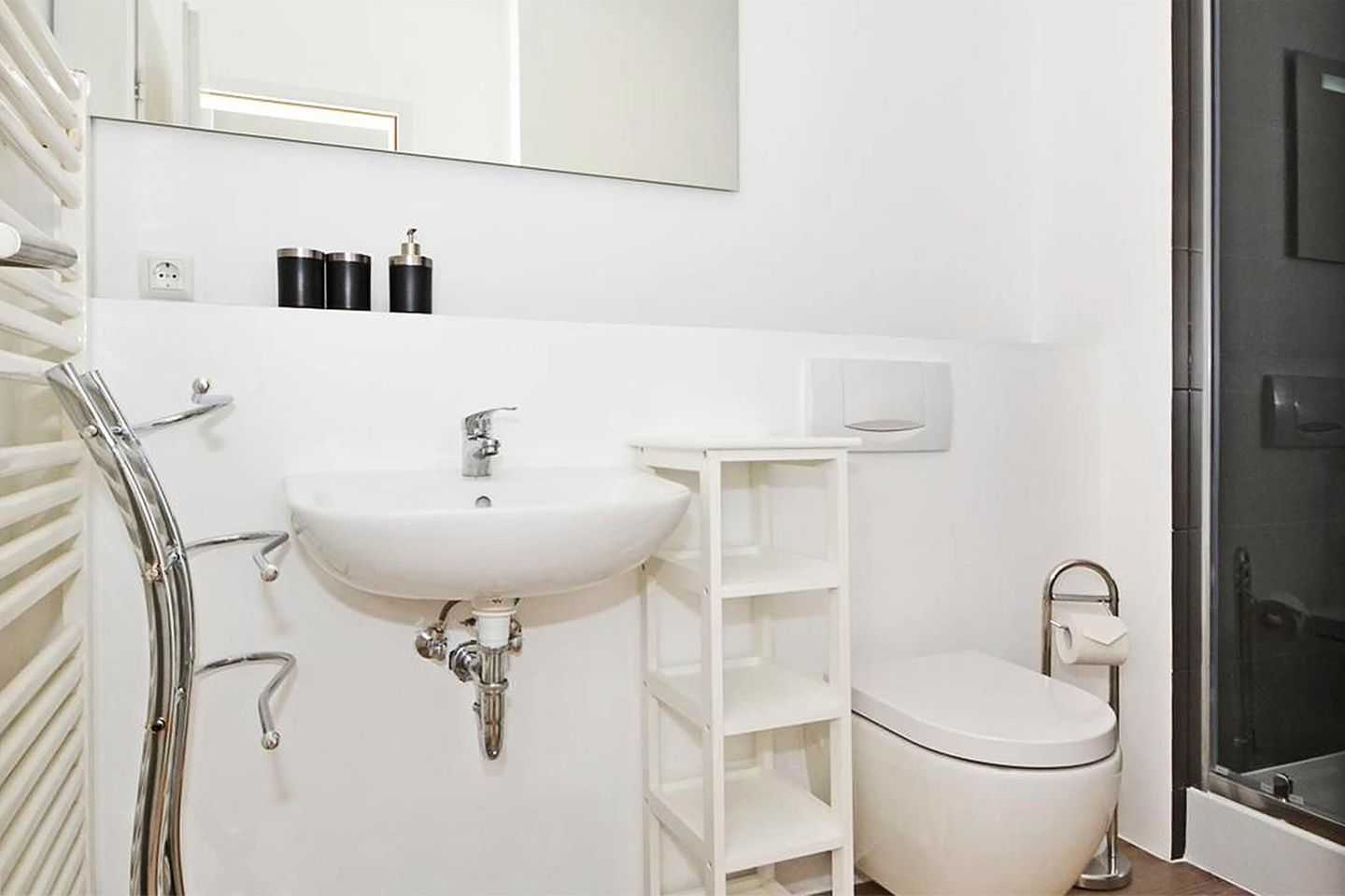 A bathroom with a white sink, a toilet, and a shower area.