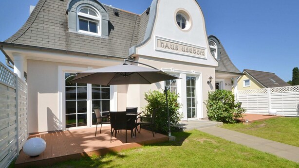 A house with a covered patio, a dining area, and a garden.