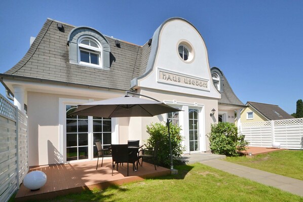 A house with a covered patio, a dining area, and a garden.
