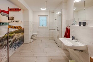 Ein modernes Badezimmer mit Toilette, Dusche und Waschbecken.