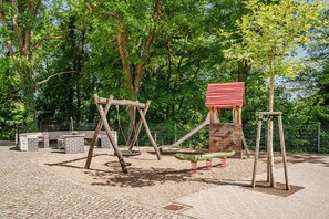 A playground with swings, a slide, and a climbing structure.