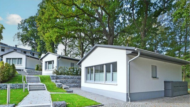 A modern residential building with a flat roof, large windows, and a paved driveway leading to a set of stairs. - Modern bungalow in Heringsdorf with sauna, garden and close to the beach - Villa Doris (Heringsdorf)