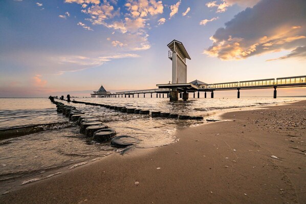 A pier extending into the water with a viewing platform and a tall structure at the end.