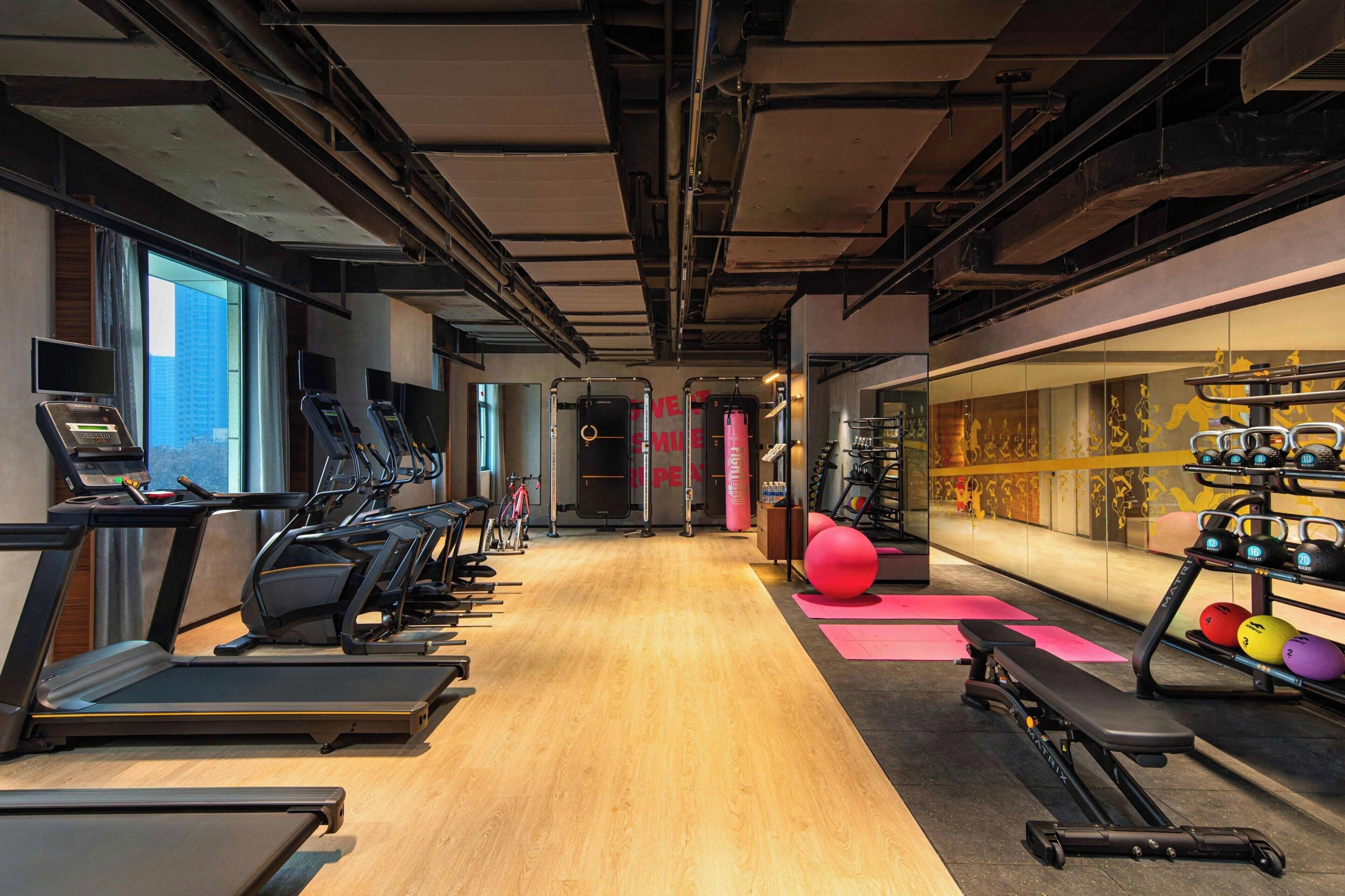 A gym with treadmills, exercise balls, and weight equipment.