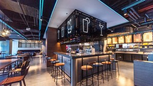 A modern bar area with a bar counter, stools, and a neon sign above. - Moxy Xi'An Beilin (Xi'an)