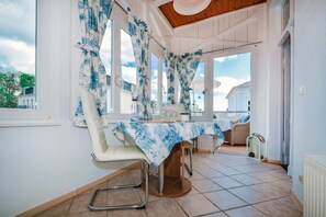 Ein Essbereich mit Tisch, Stühlen und Vorhängen.