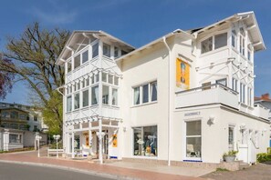 A white building with multiple windows, a balcony, and a sign reading 'SEESTRASSE 7'.