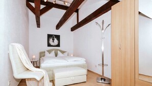 Una camera da letto con un letto, una sedia, un armadio e un appendiabiti.