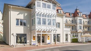 Un edificio con una facciata bianca caratteristica, ampie finestre e un balcone.