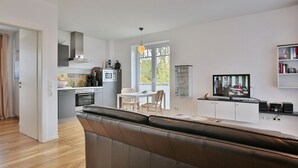 A modern apartment with a kitchen, dining area, and living room. - Villa Marisol Apartment 4 - Villa Marisol (Timmendorfer Strand)