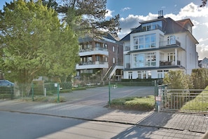 En boligbygning med en lukket indgang, flere altaner og en murstensfacade.
