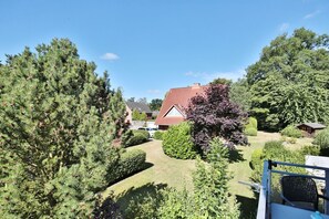Un quartiere residenziale con una casa, un prato e diversi alberi.
