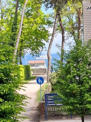 A pathway leading to a building with a sign indicating directions to various locations.