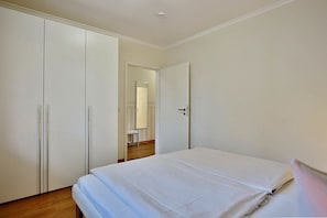Une chambre à coucher comprenant un lit, une armoire et une porte donnant sur une salle de bain.