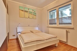 Un dormitorio con cama, ventana y radiador.