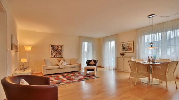 Ein modernes Wohnzimmer mit einer Couch, einem Esstisch mit Stühlen und einem Couchtisch.
