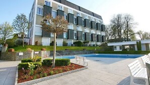 A modern apartment building with a swimming pool and outdoor seating area. - Treffert Apartment 38 - House Miramar (Timmendorfer Strand)