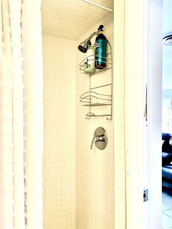 A bathroom with a shower, a towel rack, and a shampoo bottle on a shelf. - 🦋Private Studio Near the Sphere & Shared Pool by Prior Arrangement. (Paradise)