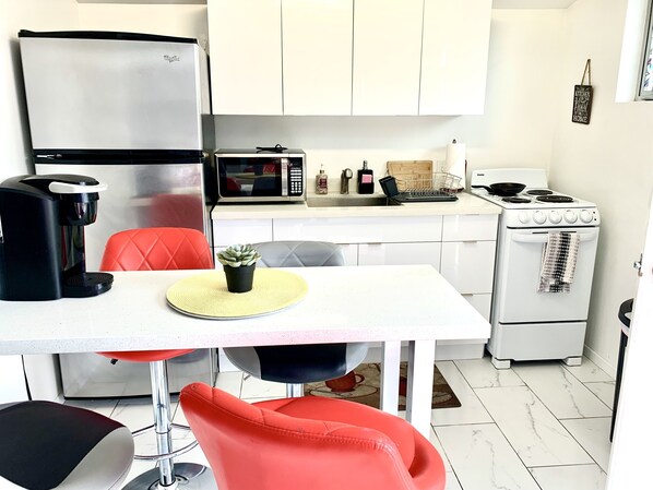 A compact kitchen with a refrigerator, microwave, coffee maker, and stove. - 🦋Private Studio Near the Sphere & Shared Pool by Prior Arrangement. (Paradise)