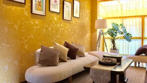 Ein modernes Wohnzimmer mit einer Couch, Kissen, einem Couchtisch und gerahmten Kunstwerken an der Wand.