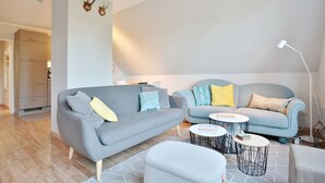 A modern living room with two sofas, a coffee table, and a lamp. - Am Rosenhain 6 Apartment 5 - Am Rosenhain 6 (Timmendorfer Strand)