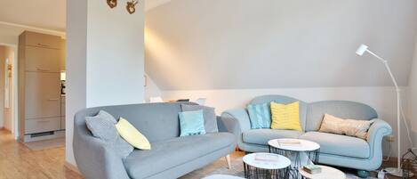 A modern living room with two sofas, a coffee table, and a lamp.