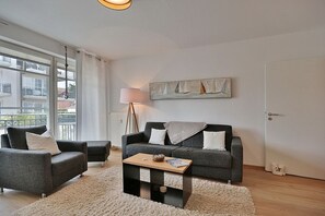 A modern living room with a grey sofa set, a coffee table, and a lamp.