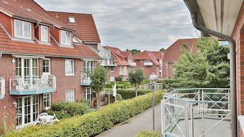 A residential area with brick houses, balconies, and a paved pathway.