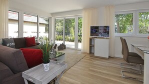 Un soggiorno moderno con un divano, un tavolino da caffè e una televisione.