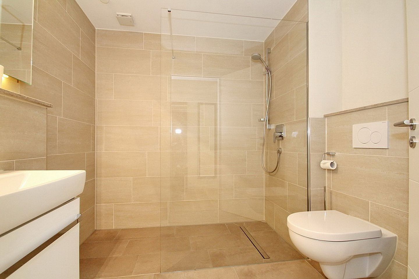 A modern bathroom with a shower, toilet, and sink.
