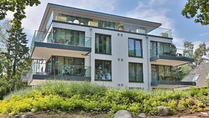 A modern multi-story house with large windows, balconies, and a well-maintained garden. - Villa Stern Apartment 10 - Villa Stern (Timmendorfer Strand)