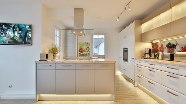 Una cocina moderna con una isla central, electrodomésticos integrados y un diseño minimalista.