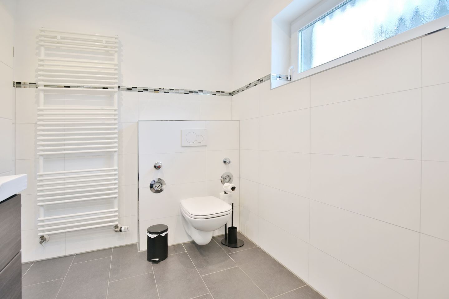 Une petite salle de bain moderne, équipée de toilettes, d’un bidet et d’une fenêtre.